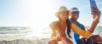 couple on a beach wearing hat and sunglasses